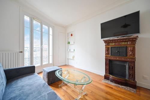 un salon avec un canapé et une cheminée dans l'établissement Apartment Suite Parties 17, à Paris