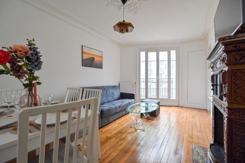 un salon avec un canapé et une table dans l'établissement Apartment Suite Parties 17, à Paris