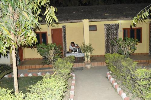 a person sitting in the window of a house at Bardia Wild Side Hotel in Bhurkīā