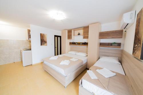 a room with two beds and a kitchen in it at Azzuro apartments Budva in Budva