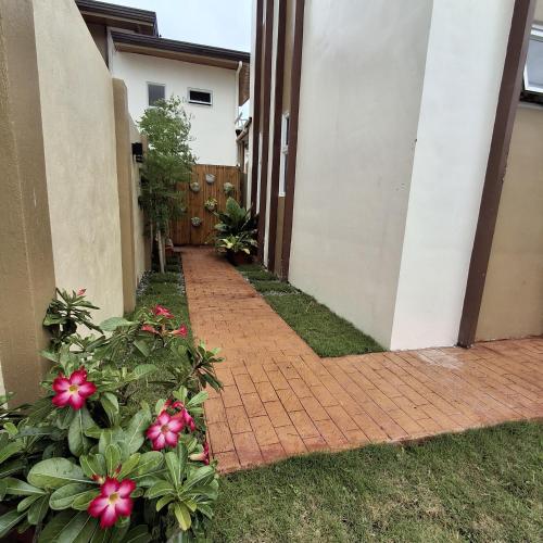 a brick walkway outside a house with pink flowers at Vacation Home near Panglao Airport and White Sand Beaches in Biking