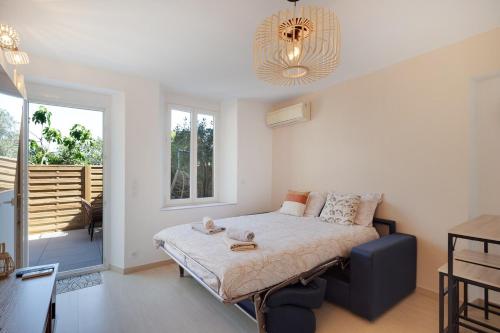 une chambre avec un lit et un lustre dans l'établissement Studio avec Terrasse et piscine, à Antibes