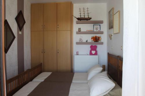 a bedroom with a bed and some wooden cabinets at Villa Moné in Koskinou
