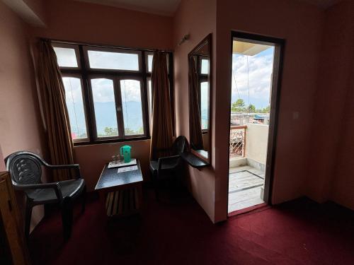 a room with a door and a table and a window at Denzong Regency in Gangtok