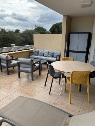 un patio avec une table, des chaises et un canapé dans l'établissement Île Rousse - Vue mer, à La Celle-sous-Gouzon