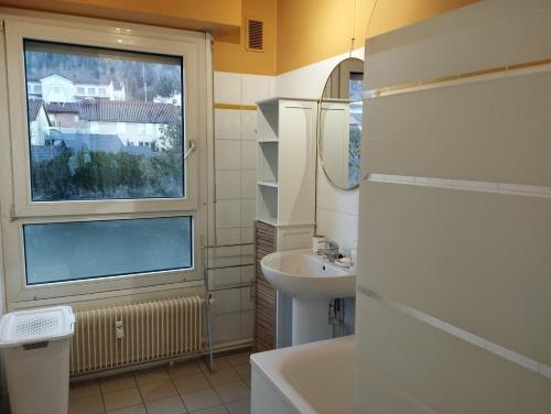une petite salle de bain avec un lavabo et une fenêtre dans l'établissement F3 rénové, à Arbent