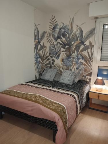 - une chambre avec un lit orné d'un mur fleuri dans l'établissement F3 rénové, à Arbent