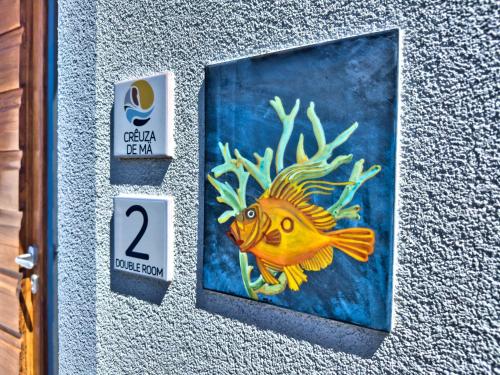 a painting of a yellow fish on a wall at Crêuza de Mä in Riomaggiore
