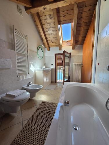 a large bathroom with a tub and a toilet at Appartamento Sofia in Mergozzo