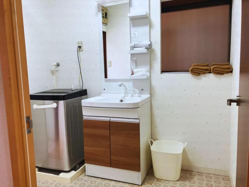 a small kitchen with a sink and a trash can at 二本木の宿 in Kumamoto