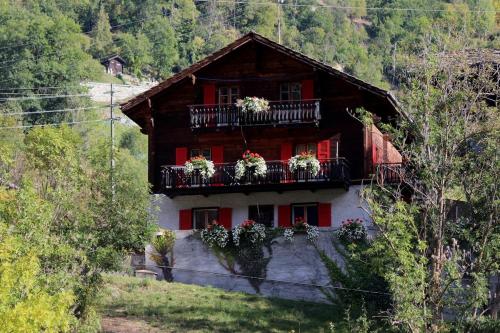 a house with flowers on the balconies of it at Chalet Chinegga in Stalden