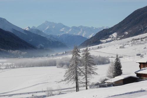 a snow covered field with mountains in the background at Chalet Chinegga in Stalden