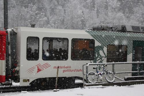 a bike is parked next to a truck in the snow at Chalet Chinegga in Stalden