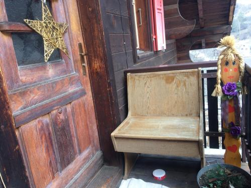 a wooden door with a wooden chair next to a door at Chalet Chinegga in Stalden