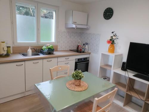 une petite cuisine avec une table et une télévision dans l'établissement Studio dans maison indépendante, à Lissieu