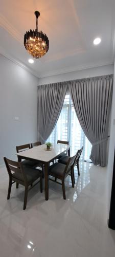 Bukit PayongにあるRaudhah Homestay Tasek Kuala Terengganuのテーブルと椅子とシャンデリアのあるダイニングルーム