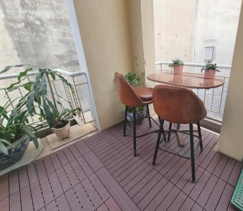 a table and chairs on a balcony with plants at LushStay Hanoi Train Street - Cozy in Hanoi