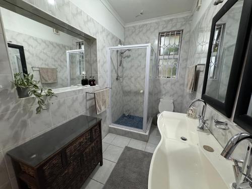 ein Badezimmer mit Dusche, Waschbecken und Badewanne in der Unterkunft Serene waterfront escape! Luxury, King bed! in Durbanville