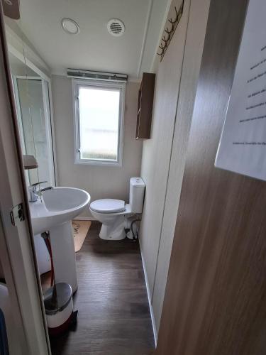une petite salle de bain avec toilettes et lavabo dans l'établissement Mobihome Comfort 3 chambres 6 Personnes, à Clohars-Carnoët