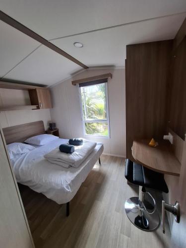 une chambre avec un lit et une fenêtre dans l'établissement Mobihome Comfort 3 chambres 6 Personnes, à Clohars-Carnoët