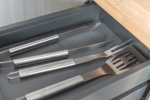 a knife and other kitchen utensils in a drawer at Apartament Ustka Holiday z sauną i ogrodem in Ustka