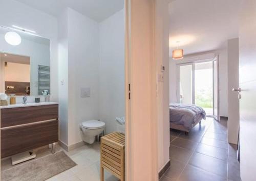 une salle de bain avec un lavabo et des toilettes et un lit dans l'établissement Domaine Blue Park 2 pièces, piscine, jardin privé, climatisation, parking et vue, à Antibes