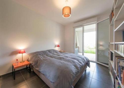 - une chambre avec un lit et 2 tables avec des lampes dans l'établissement Domaine Blue Park 2 pièces, piscine, jardin privé, climatisation, parking et vue, à Antibes