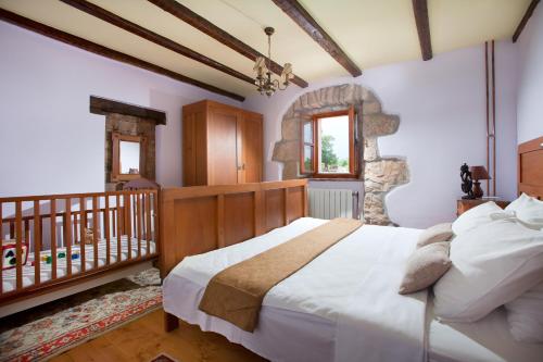 a bedroom with a large bed and a crib at Villa Favola, a rustic retreat surrounded by beautiful nature in Vinež