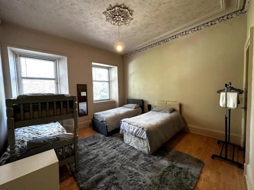 Un dormitorio con dos camas y una alfombra. en Cheerful 5 Bedroom House Close to Central West End and Parking, en Glasgow