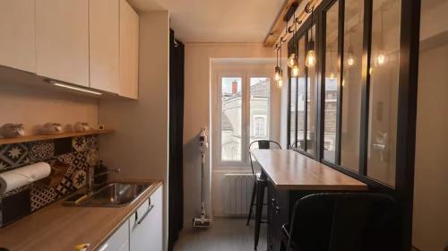 une cuisine avec un comptoir, un évier et une fenêtre dans l'établissement L'Escapade Central - Gare, à Mâcon