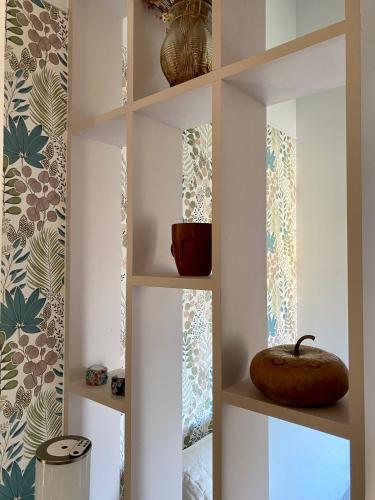 - une étagère avec un bol dans une pièce dans l'établissement La paisible, maison familiale et conviviale en Baie de Somme, à Vaudricourt