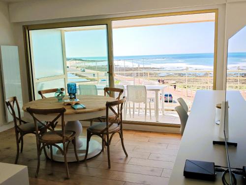 une salle à manger avec une table et une vue sur l'océan dans l'établissement La parenthese bleue, à La Rudelière