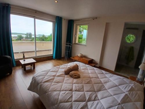 a bedroom with a large bed and a large window at natura in Sallenelles