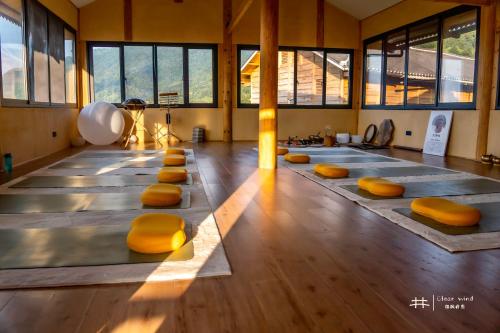 a yoga class with yellow cushioned chairs in a room at The Well House in Jiayi