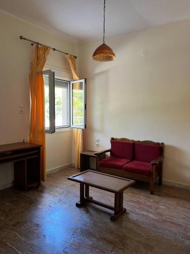 a living room with a red couch and a table at Olives house Chios island in Emporeios