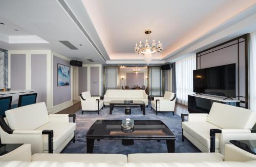 a living room with white furniture and a flat screen tv at Shangrao International Hotel in Shangrao
