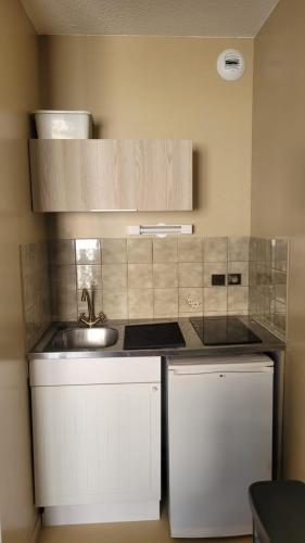 a small kitchen with a sink and a refrigerator at Appartement BARBOTAN LES THERMES in Cazaubon