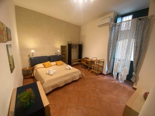 una camera da letto con un letto grande e un tavolo di Casa Angelica a Siracusa