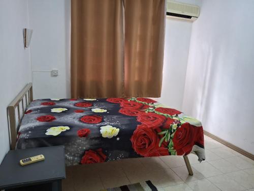 a bedroom with a bed with flowers on it at Apartment Nashou in Grand Baie