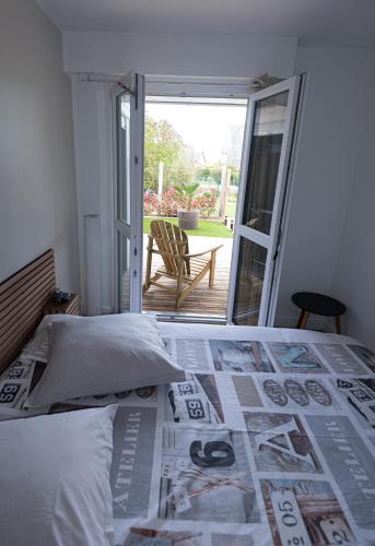 un lit dans une chambre avec un journal dessus dans l'établissement Bel appart près du port et de la plage, à Courseulles-sur-Mer