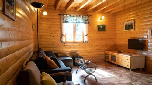 a living room with a couch and a television at Chalets Runolist in Crni Lug