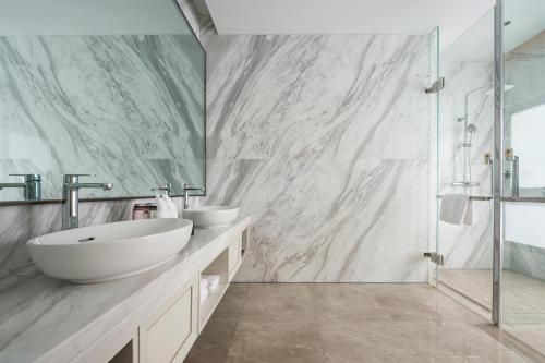 a bathroom with two sinks and a glass shower at Shangrao International Hotel in Shangrao
