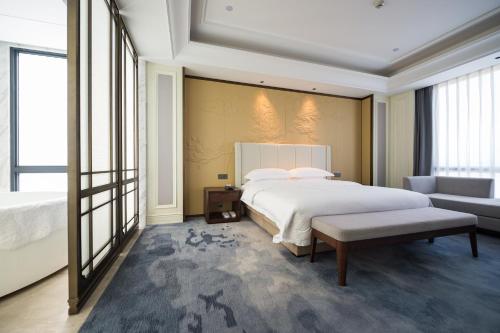 a bedroom with a large white bed and a couch at Shangrao International Hotel in Shangrao