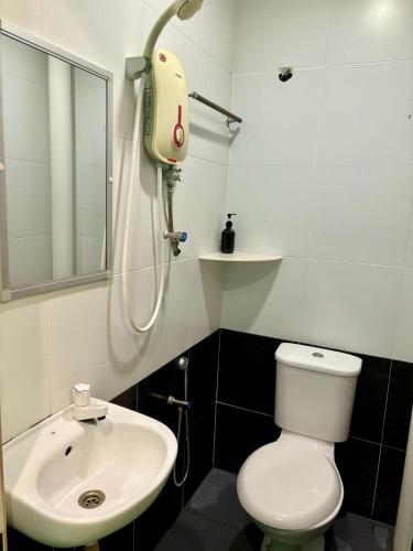a bathroom with a white toilet and a sink at Qish Hotel Melaka in Malacca