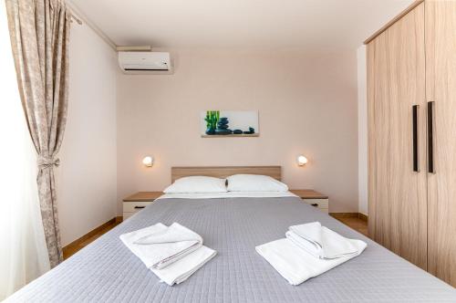 a bedroom with a bed with white towels on it at Bed and Breakfast Ivona in Baška Voda
