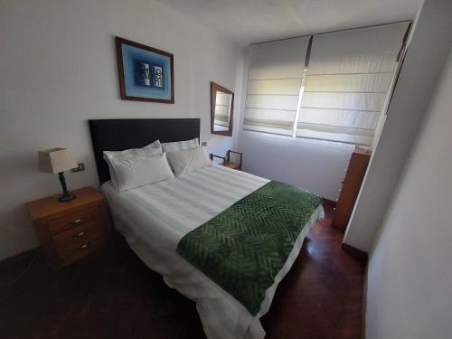 a bedroom with a large bed and a window at Sunmari in A Pobra do Caramiñal