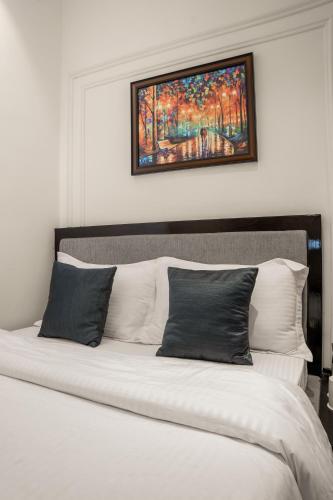 a bedroom with a bed with a painting above it at Hotel Ichamati in Kolkata
