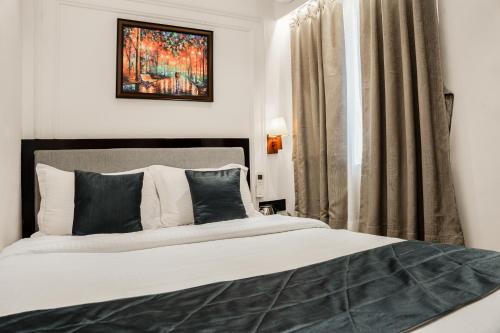 a bedroom with a large bed and a window at Hotel Ichamati in Kolkata