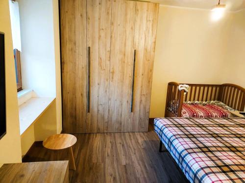 a bedroom with a bed and a wooden door at Pasubio 13 in Selvino