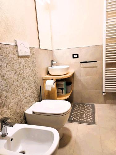 a bathroom with a white toilet and a sink at Pasubio 13 in Selvino